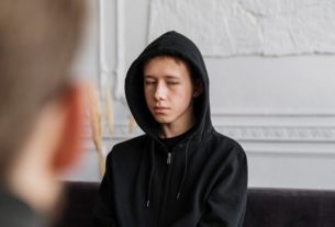 Boy in hood facing blurred man image